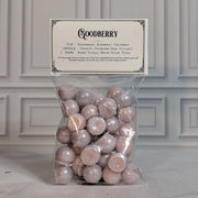 Goodberry wax melt drops in a sealed cello bag with a navy and gold topper card, on white marble